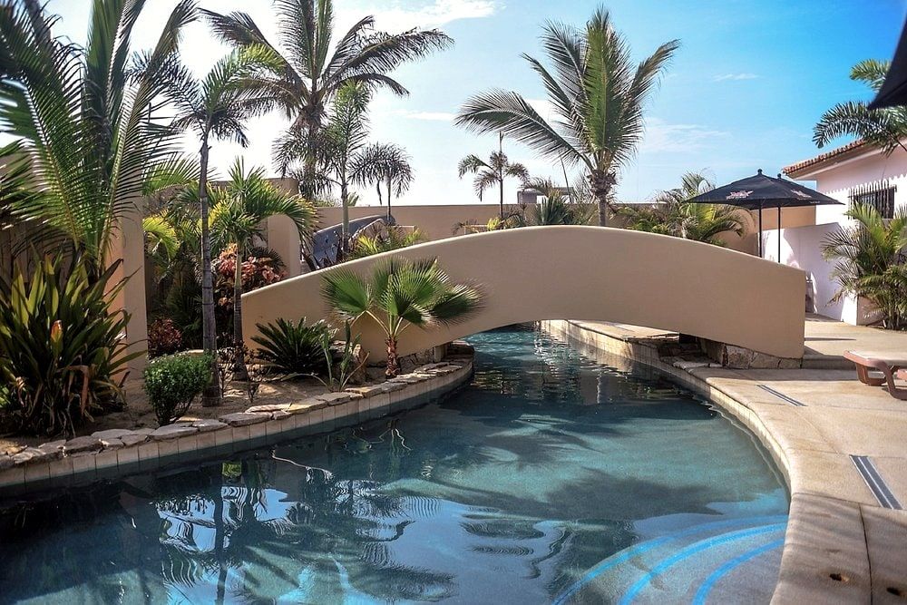 A footbridge crossing the pool, planted with palms and desert flowers
