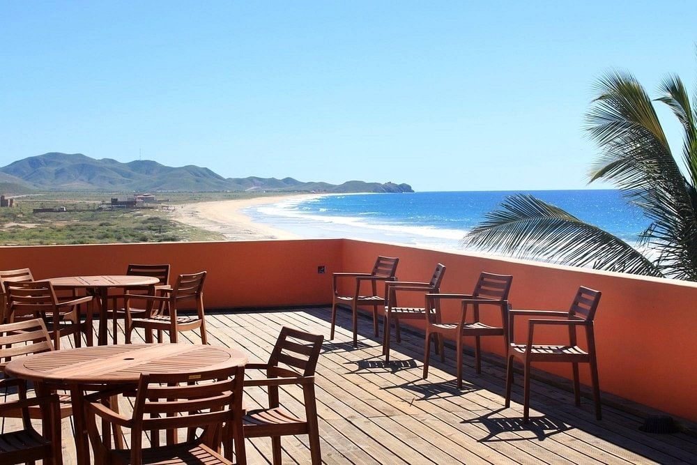 The rooftop deck with wooden loungers looking out over Playa Los Cerritos