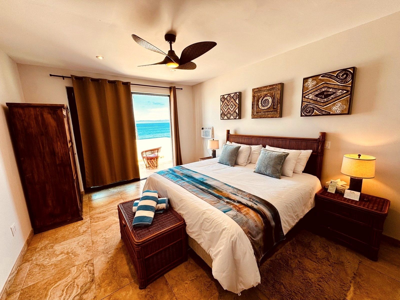 A Deluxe King room with the bed facing full-height glass doors onto the Pacific