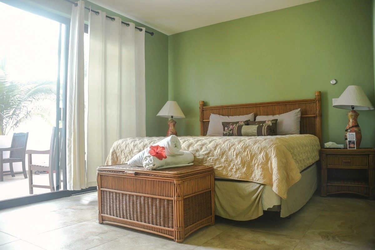 A quiet mountain-view guest room with a queen bed and rattan chest