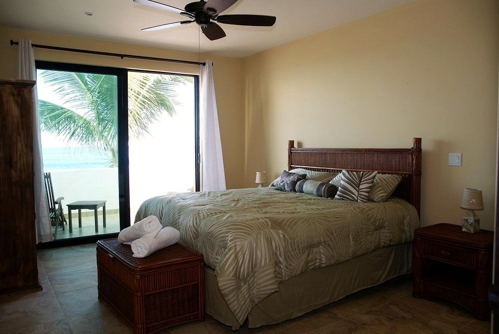 Sliding glass doors open from a guest room straight onto the beach