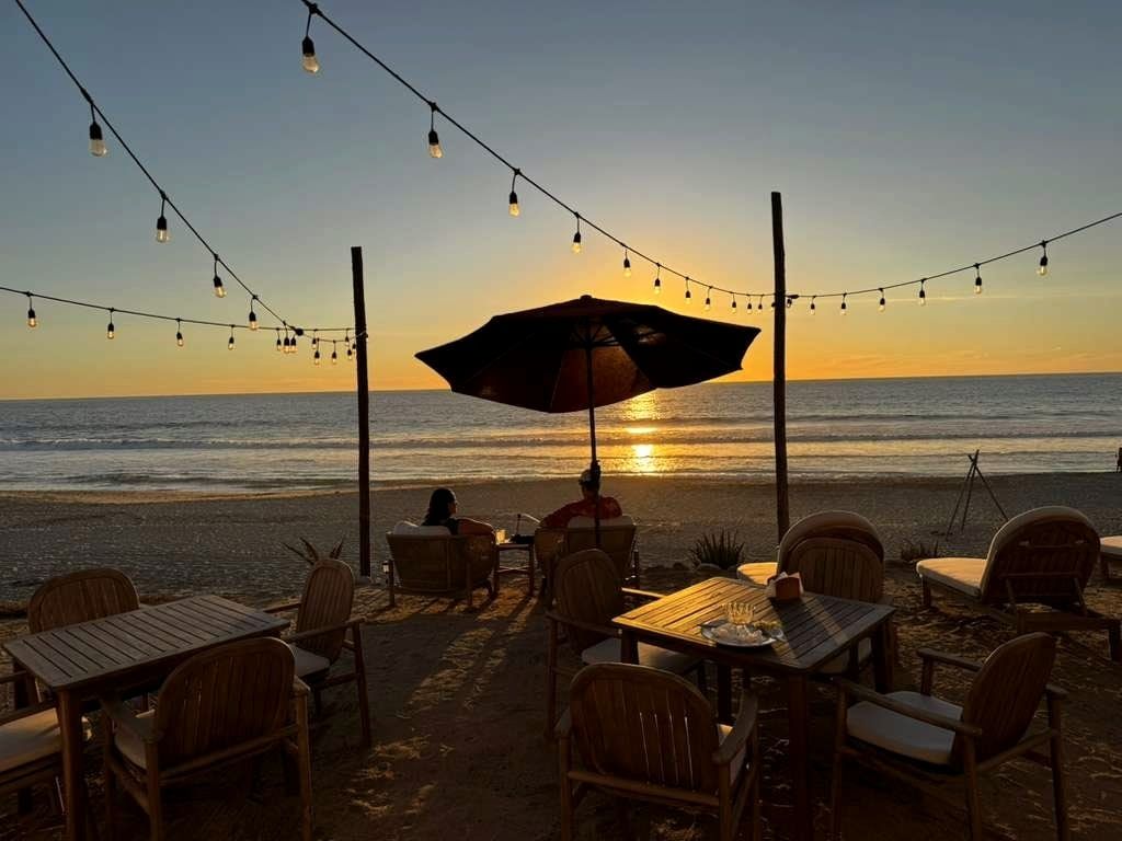 A parasol and beach chairs on the terrace at golden hour